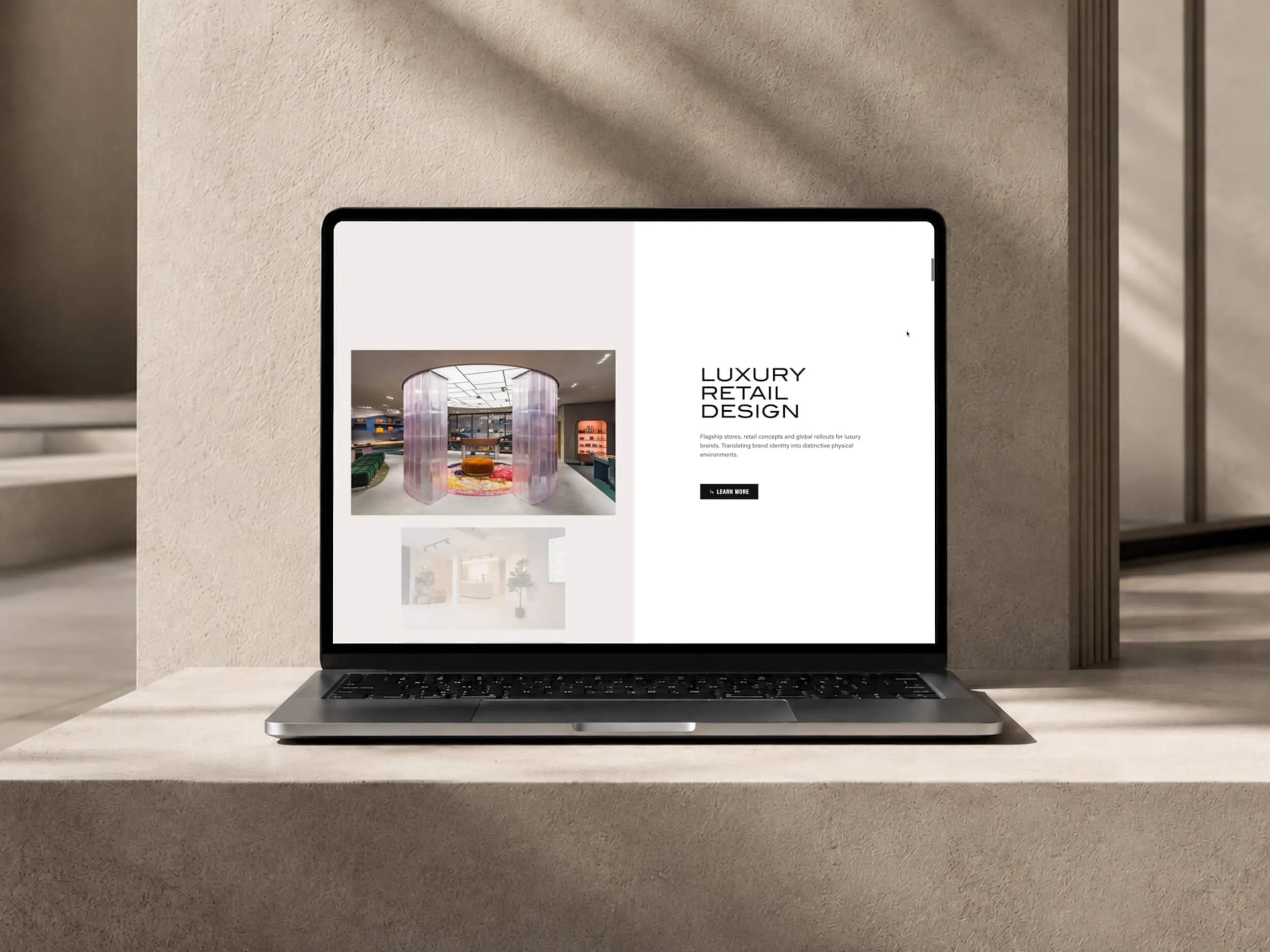 Laptop displaying Bradley Taylor Design's luxury retail design webpage in a neutral architectural setting.
