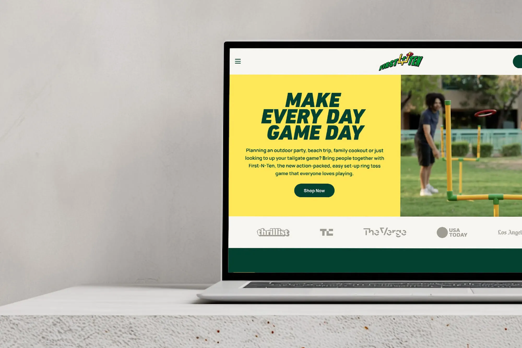 Mock-up of First-N-Ten homepage on a laptop against a gray background.