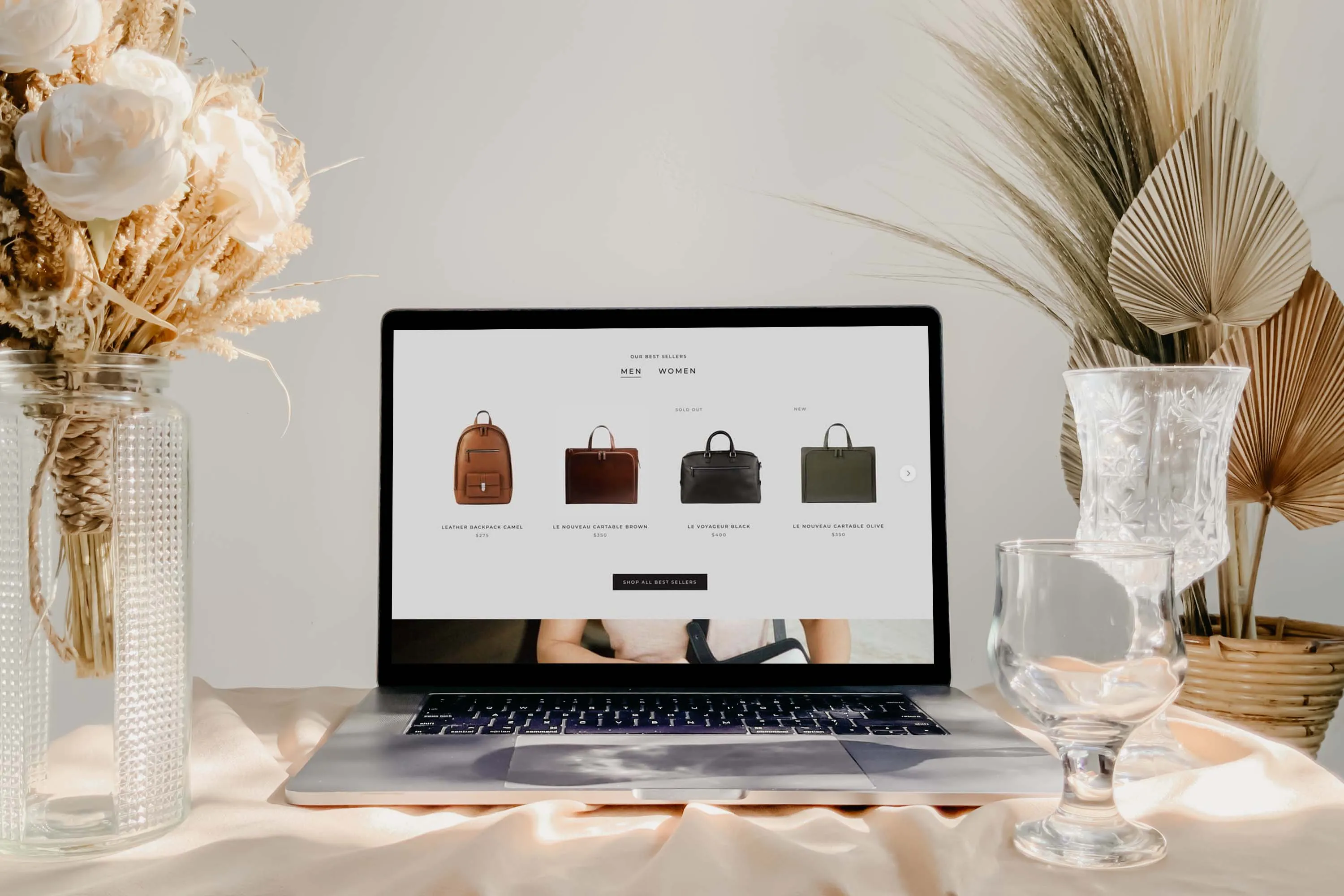 Prestige screenshot on laptop screen against luxurious background with crystal glasses and dried flowers.