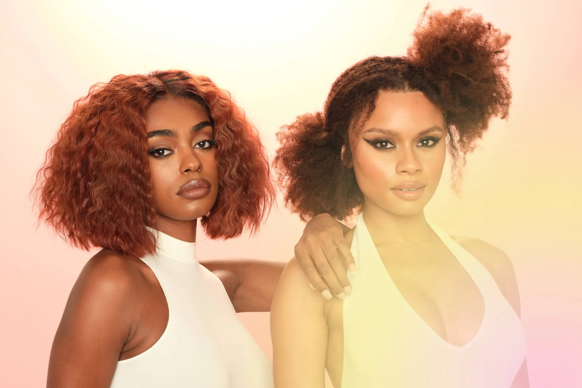 Two models wearing Parfait wigs stand against a pink and yellow gradient background, looking at the camera.