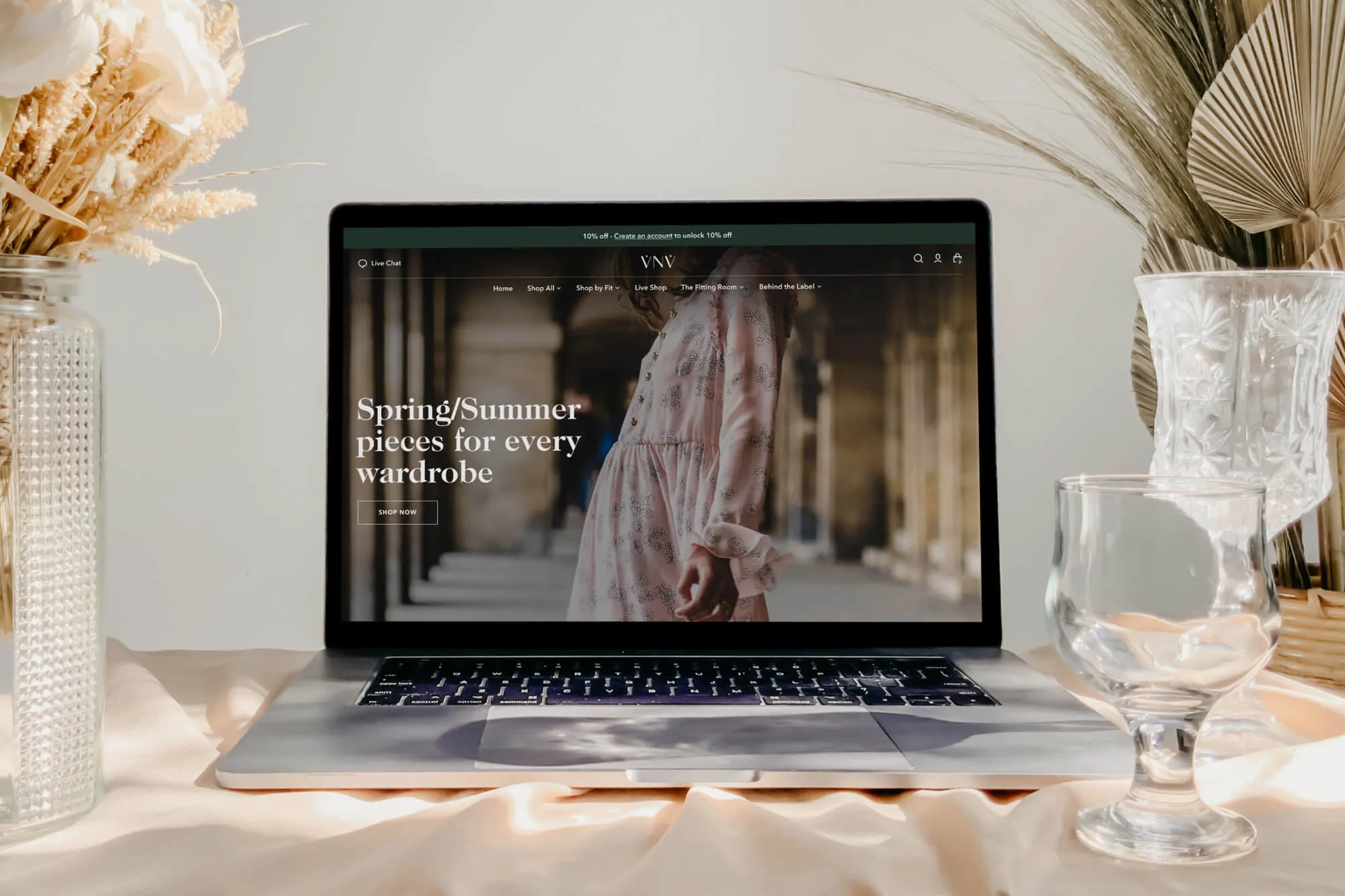 Mock-up of VNV homepage against a luxurious satin and dry flower background.